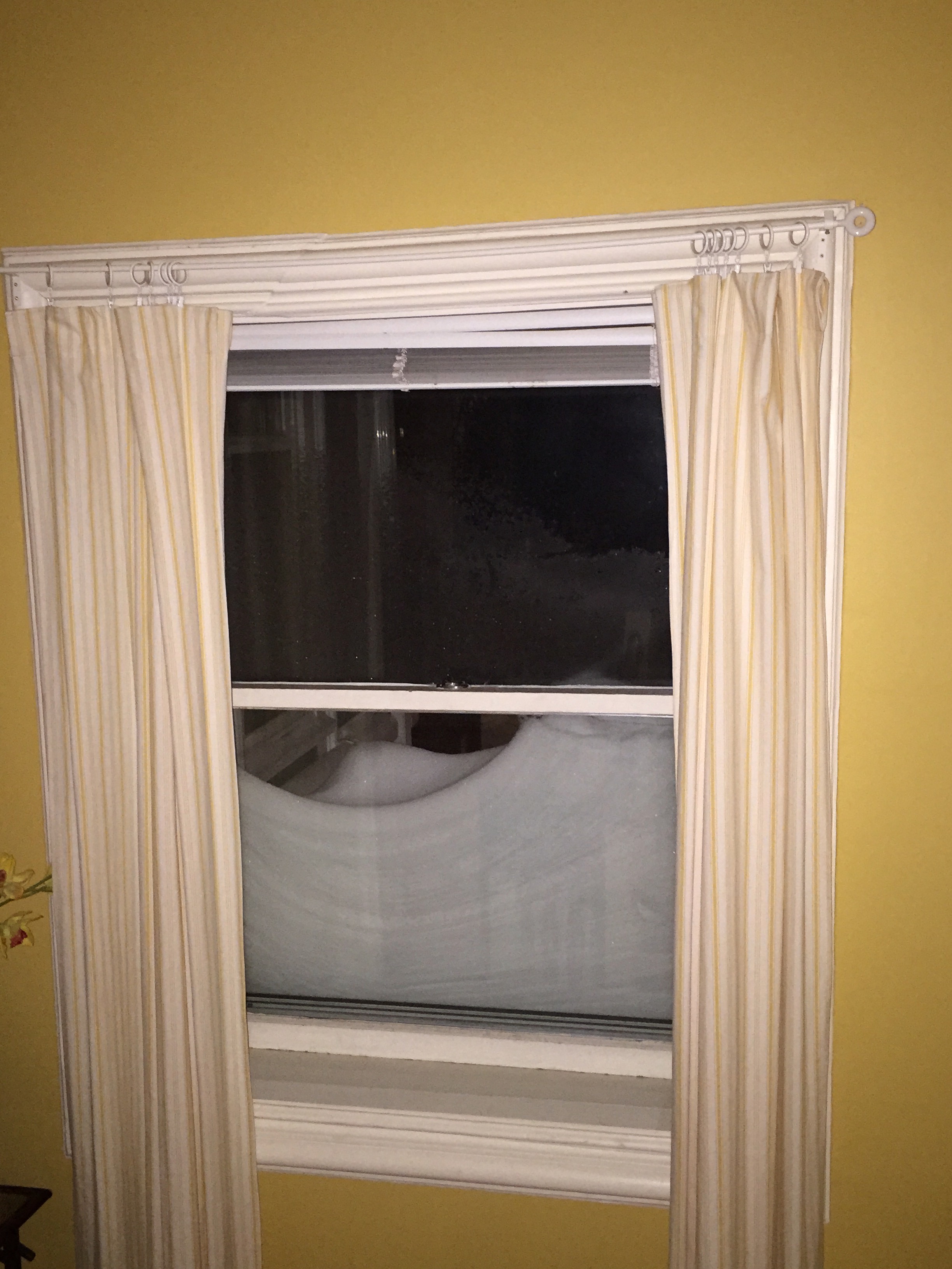 Half of the window frame is covered in snow